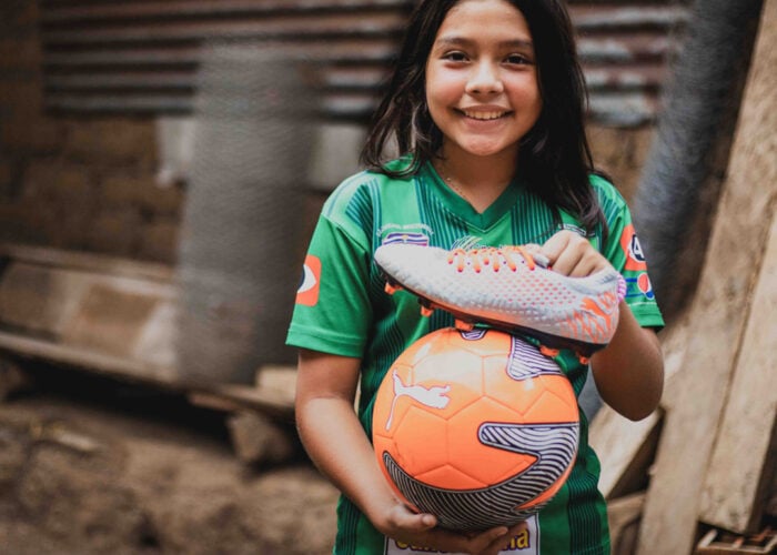 alt="Karlas Geschichte, Fußball spielen ist ihr Hobby, Karla mit Fußball in der Hand, El Salvador"