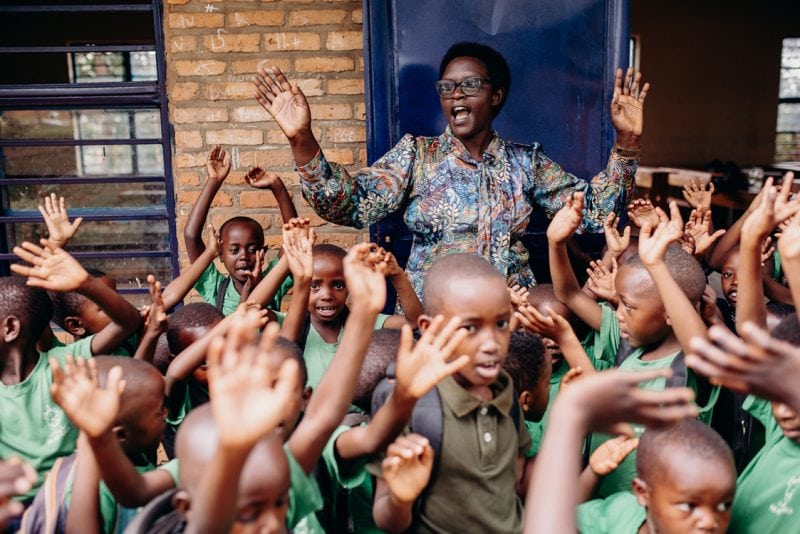 alt="Ein Tag im Compassion Kinderzentrum in Ruanda. Der Tag im Kinderzentrum ist so gut wie vorbei und die Kinder ziehen ihrer Schulränzen an und verabschieden sich."