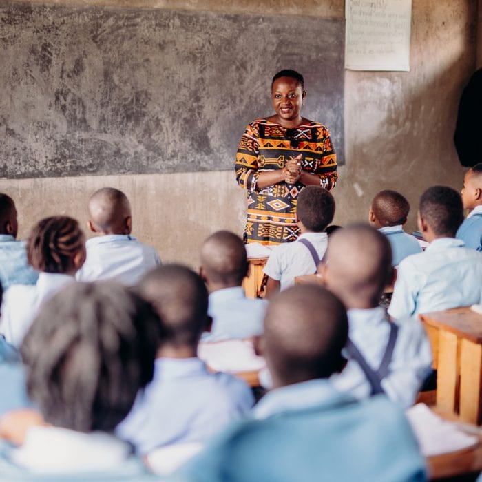 alt="Der Kampf des Vergebens, Compassion Deutschland, Eine Lehrerin steht vor der Klasse und spricht zu ihren Schülern"