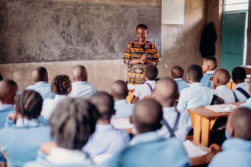 alt="Der Kampf des Vergebens, Compassion Deutschland, Eine Lehrerin steht vor der Klasse und spricht zu ihren Schülern"