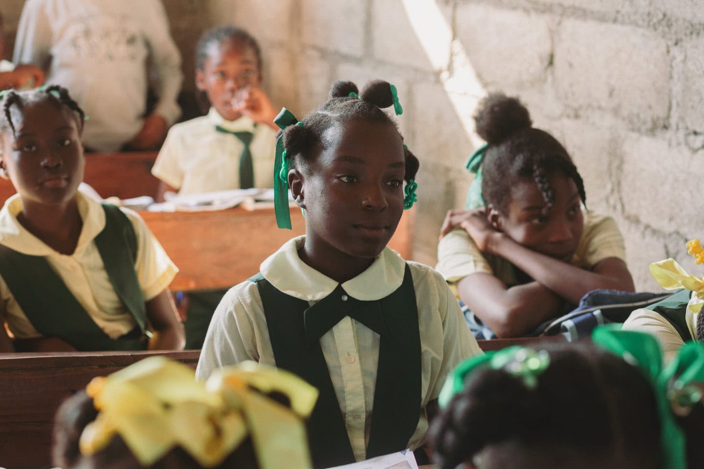 alt="Zum Neuanfang gezwungen, Zum Neuanfang gezwungen, Carolie und Laurie in Haiti, Mädchen auf einer Schulbank, Compassion Deutschland"